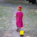 The girl walks and pulls the car behind her