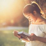 Girl reading a book under a tree