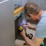 man repairing kitchen cabinet