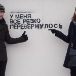 couple stands against a white wall